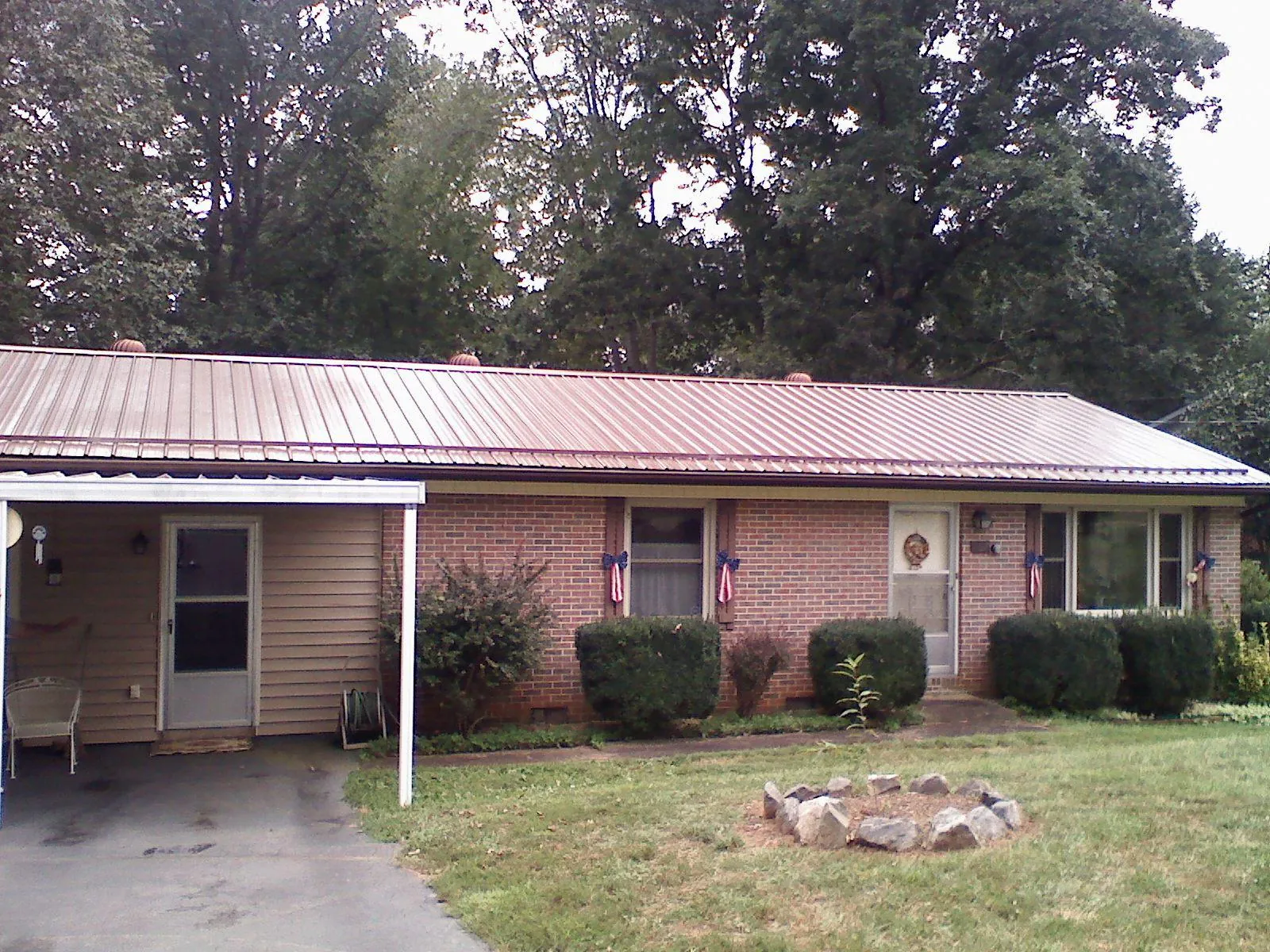 Bronze metal roof and carport on a brick ranch home — Roof Repair work by our crew in North Chicago