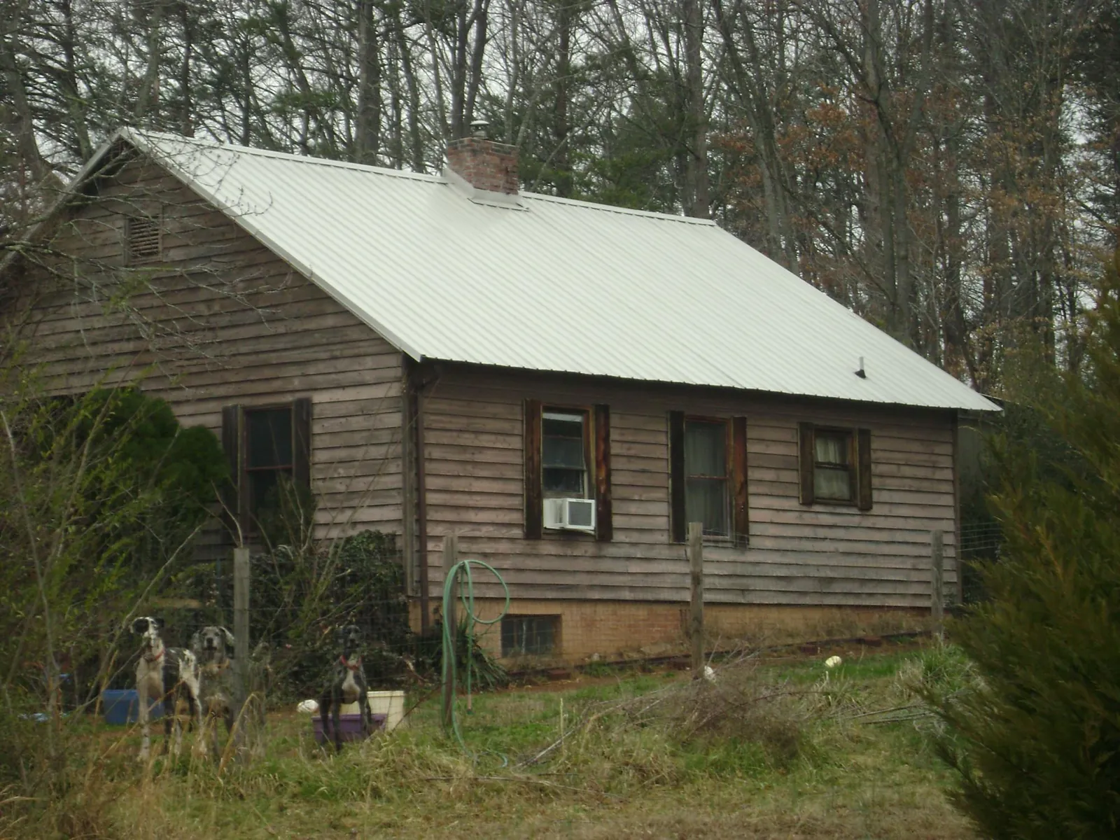 White metal roof on an old wood sided farmhouse, from a Metal Roof Installation job in North Chicago